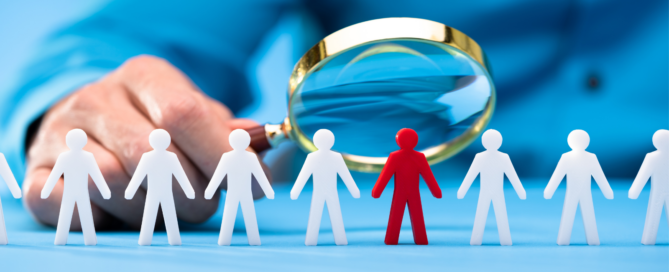 image of a person holding a magnifying glass over human figures representing Staffing Data