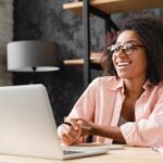 Young businesswoman behind a computer interacting with people online.