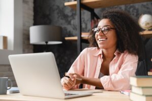 Young businesswoman behind a computer interacting with people online.