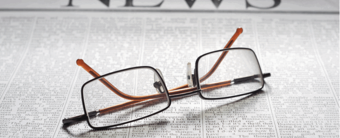 Photo of newspaper and reading glasses.