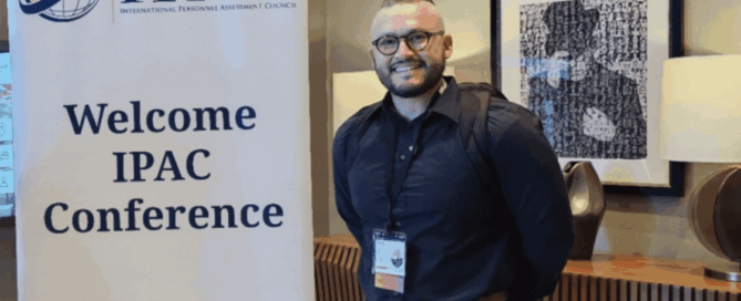 Man standing beside a sign that reads ‘Welcome IPAC Conference.